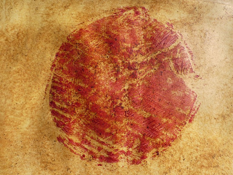 empreinte à l'encre rouge sur un fond jaune sumac