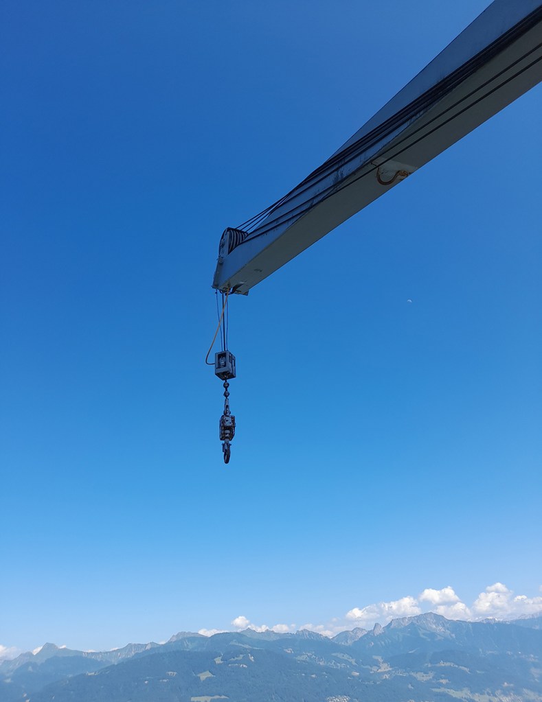 bras de grue sur fond ciel et montagnes